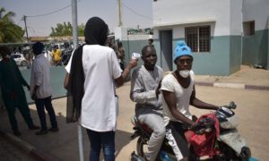 Une dame prend la températures des visiteurs à l'hôpital El Hadji Ibrahima Niass de Kaolack