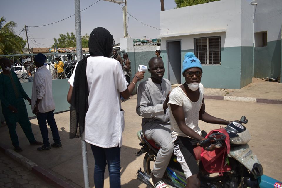 Une dame prend la températures des visiteurs à l'hôpital El Hadji Ibrahima Niass de Kaolack
