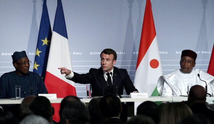 Emmanuel Macron fait un geste à côté du président nigérien Mahamadou Issoufou et du président tchadien Idriss Deby