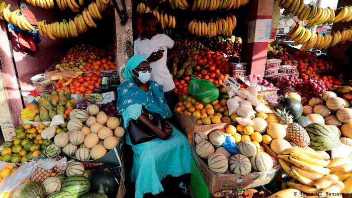 Coronavirus - Une dame porte un masque chez le vendeur de fruits