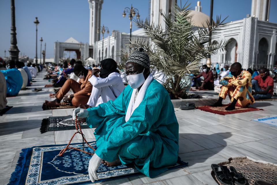 Des hommes en boubous colorés attendent la prière marquant la fin du Ramadan. (Maya Hautefeuille - Mosquée