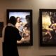 Un homme inspecte des tableaux de Léonard de Vinci lors de l'exposition