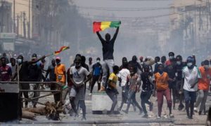 Un manifestant brandit un drapeau sénégalais lors de manifestations contre l'arrestation du chef de l'opposition et ancien candidat à la présidentielle Ousmane Sonko à Dakar, au Sénégal, le vendredi 5 mars 2021