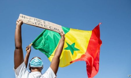 Une Sénégalaise soulève un pencarte free-senegal