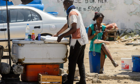 DAKAR, SÉNÉGAL - AVR 23, 2017 : un sénégalais non identifié en écharpe tient la porte du réfrigérateur à Dakar, capitale du Sénégal