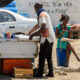 DAKAR, SÉNÉGAL - AVR 23, 2017 : un sénégalais non identifié en écharpe tient la porte du réfrigérateur à Dakar, capitale du Sénégal