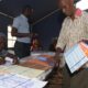 Un homme choisit des bulletins pour voter aux élections municipales et départementales du 29 juin 2014 dans un bureau de vote à Dakar, la capitale du Sénégal.