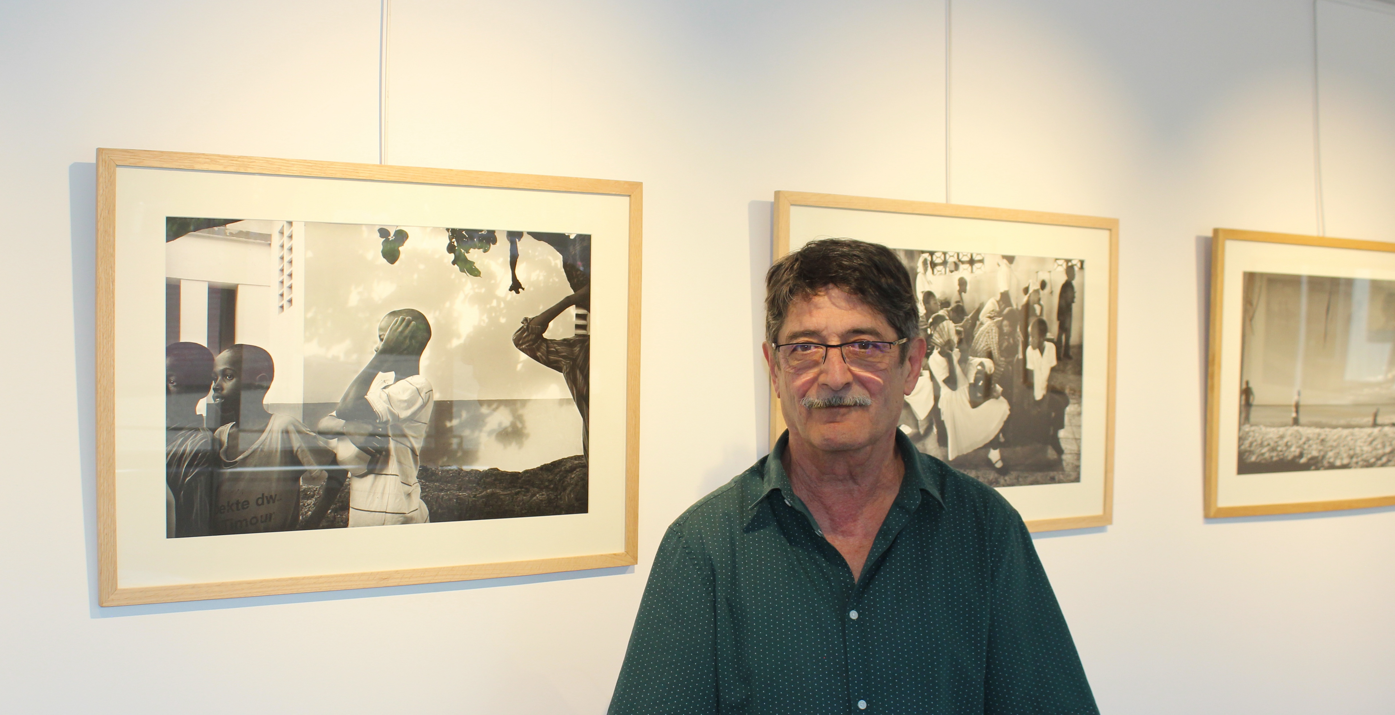 Le photographe italien Francisco Gettoni pose devant son exposition d'images prises à Port-au-Prince après le séisme de 2010 (Crédit Photo Klinfos.com)