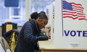 Une femme remplit son bulletin de vote anticipé, à Ottawa, dans l'Etat du Michigan. (KAMIL KRZACZYNSKI / AFP)