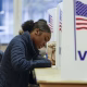 Une femme remplit son bulletin de vote anticipé, à Ottawa, dans l'Etat du Michigan. (KAMIL KRZACZYNSKI / AFP)